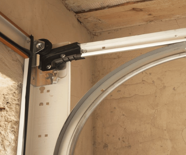 Professional technician repairing bent garage door track in San Francisco Bay Area residential garage
