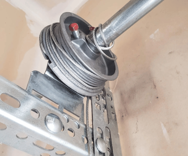 Licensed technician replacing broken garage door cable in San Francisco Bay Area residential garage