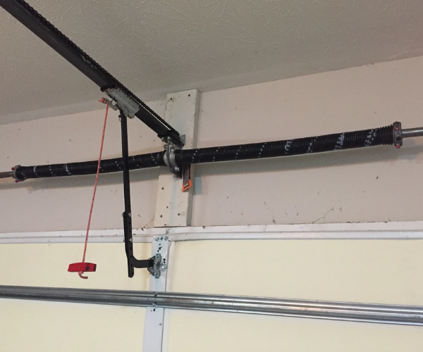 Broken garage door spring repair technician replacing torsion spring in Bay Area home