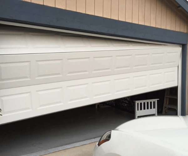 Emergency technician repairing garage door that came off track in San Francisco Bay Area home