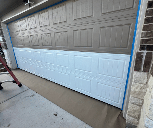 Professional technician replacing damaged garage door panel on residential home in San Francisco Bay Area