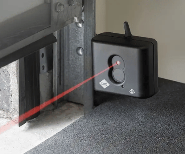 Professional technician testing garage door safety sensors and auto-reverse system in San Francisco Bay Area home